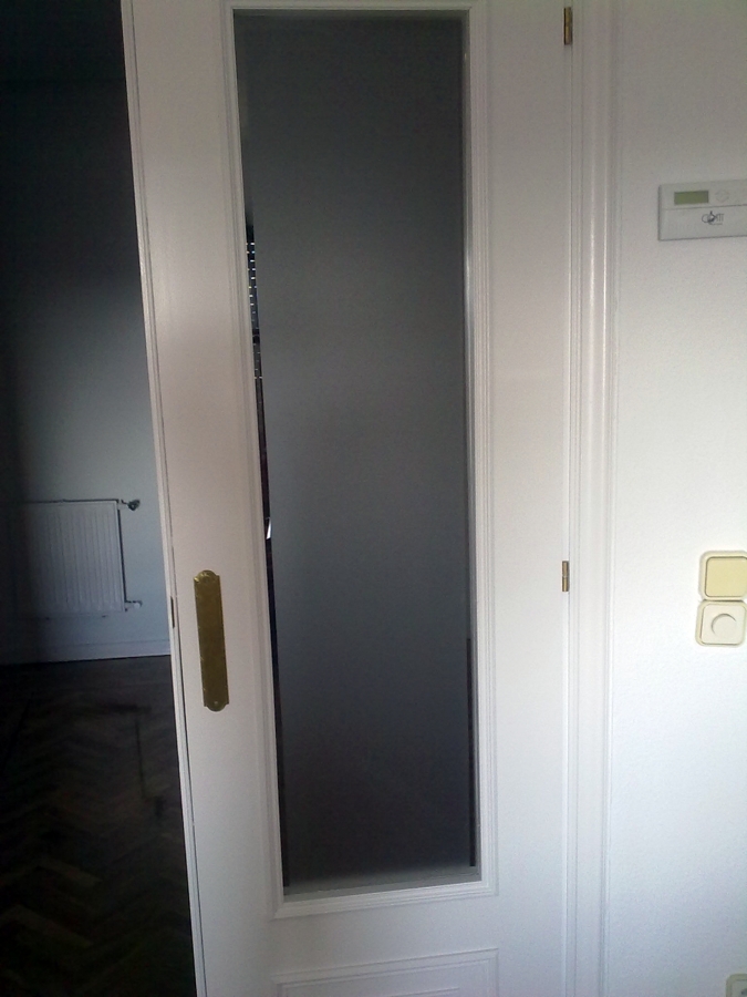 Puerta restaurada con esmalte en blanco y vidrio mateado con bisel