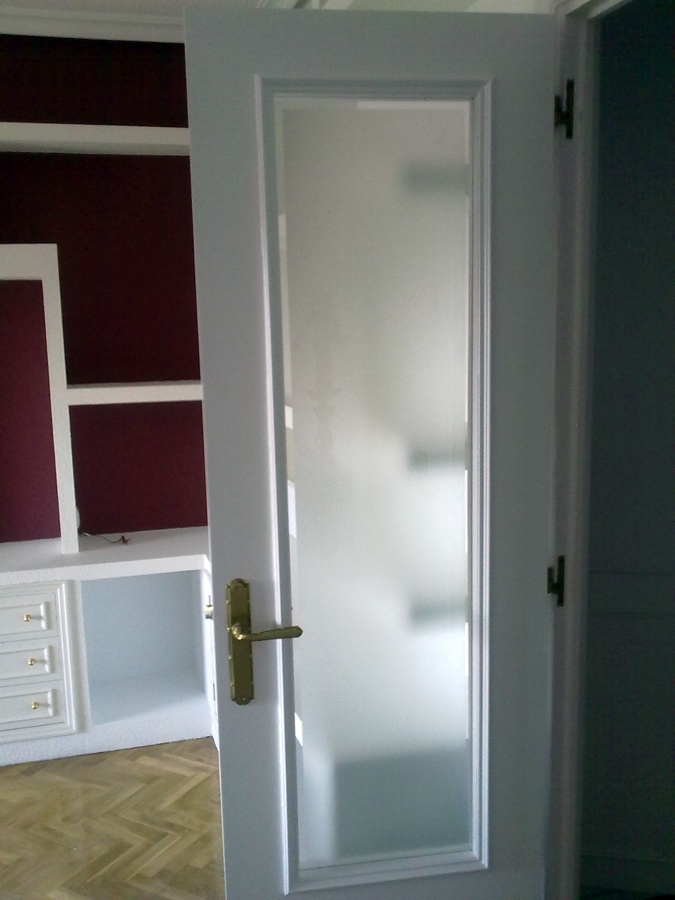 Puerta restaurada con esmalte en blanco y vidrio mateado con bisel