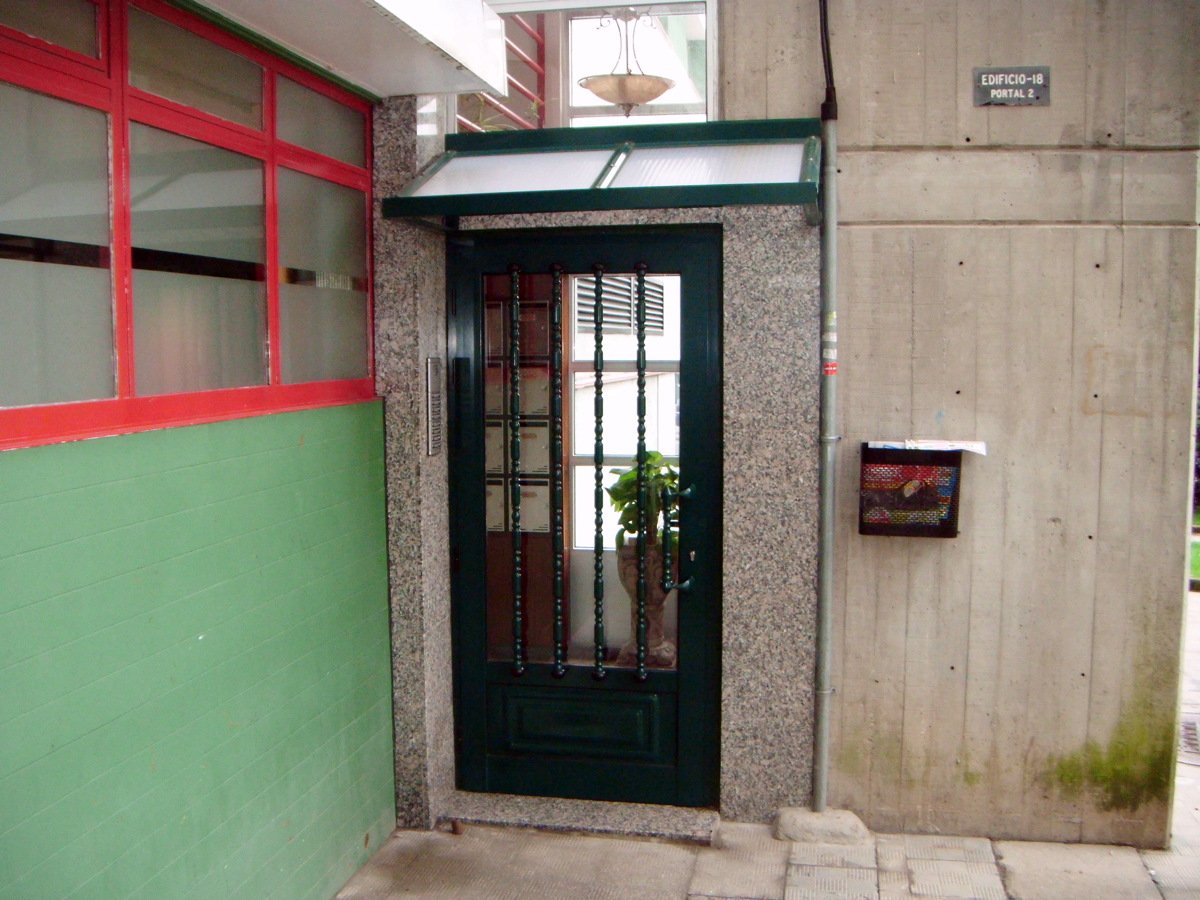 puertta de acceso con tejadillo en aluminio verde