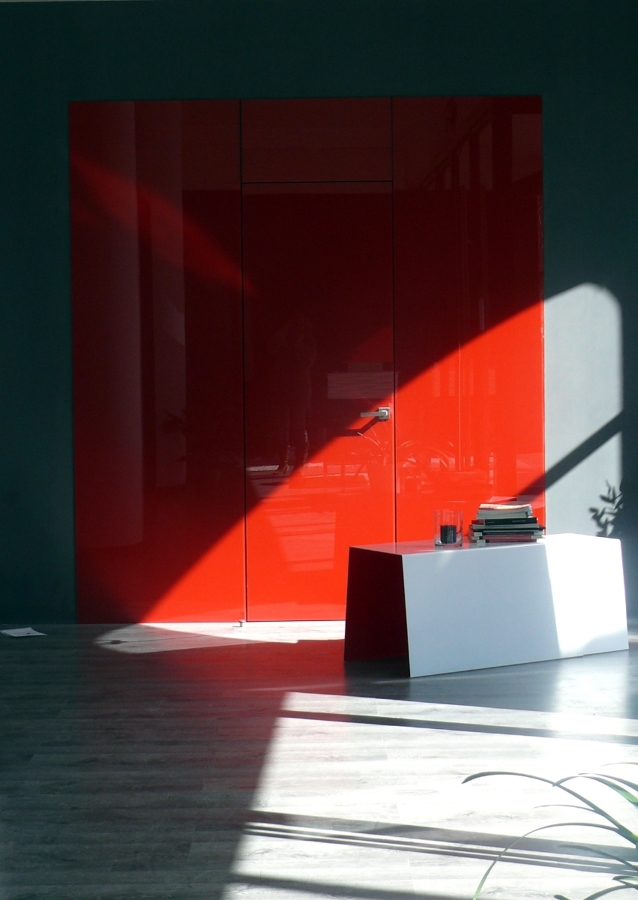 Revestimiento de pared en vidrio rojo brillo y puerta enrasada mismo acabado