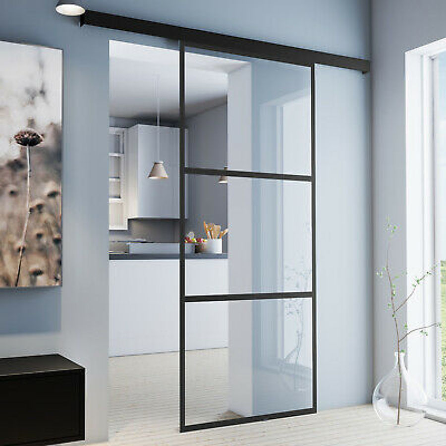 Puerta de perfilería metálica lacada en negro y vidrio.