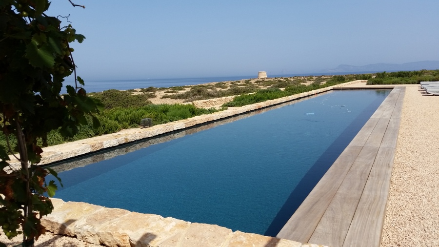 Piscina exterior en Baleares, de 24m x 4.50m desbordante oculto bajo tarima