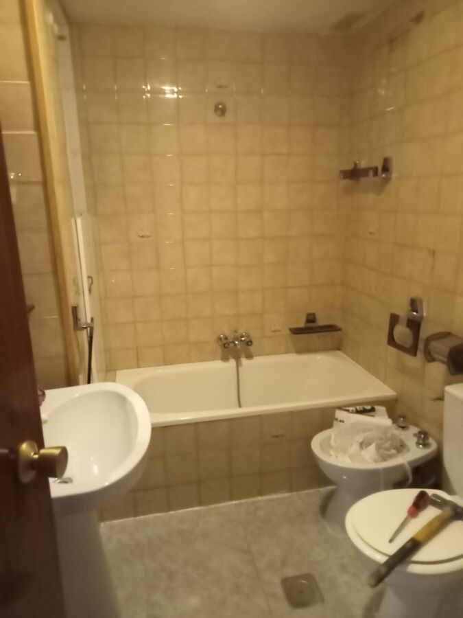Antes de reforma: Baño antiguo con bañera poco práctica y acabados pasados de modaD