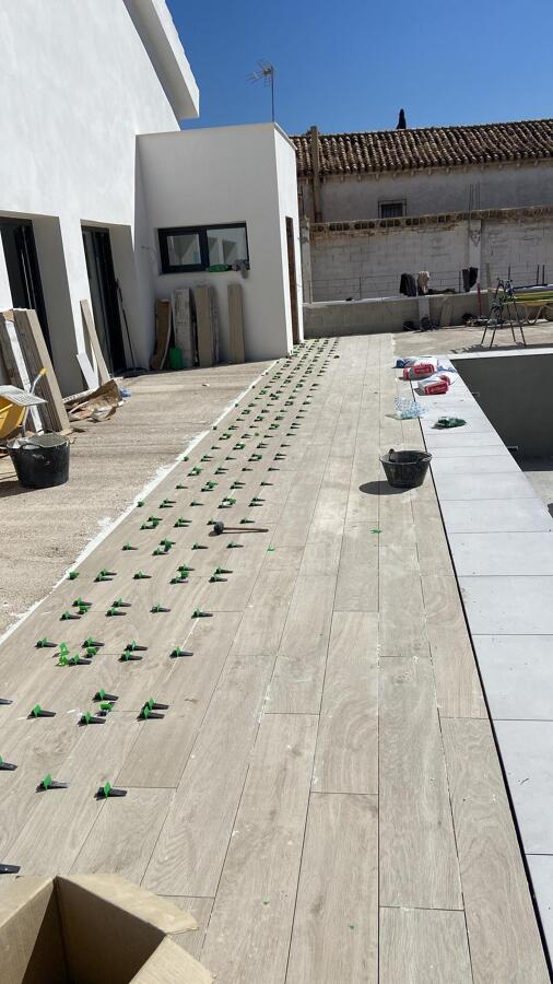 Colocación de pavimento exterior efecto madera en zona de piscina