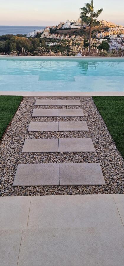 Diseño de exterior con piscina y camino decorativo en piedra natural