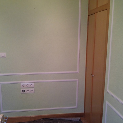 Sala de estar en color verde con moldura en blanco 