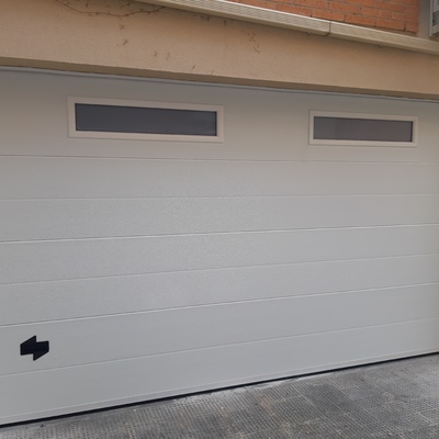 Puerta seccionable con ventanas tragaluz.