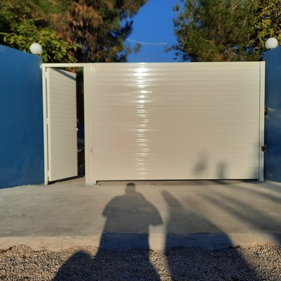 Puerta abatible motorizada y puerta peatonal en blanco