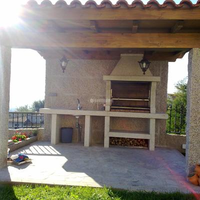 Construcción de garaje y barbacoa con estructura de madera y panel sandwich de madera.