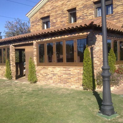 Ventanas de PVC de apertura plegable color Nogal Kömmerling.