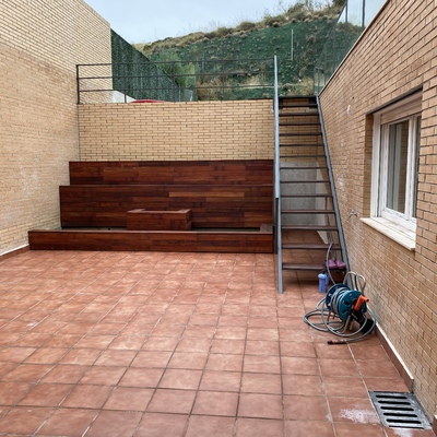 Patio con jardineras, suelo y escalera de forja