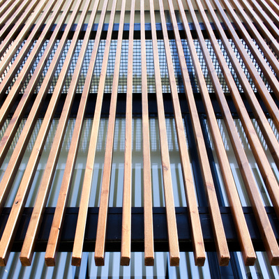 Fachada de vidrio con filtro solar de madera