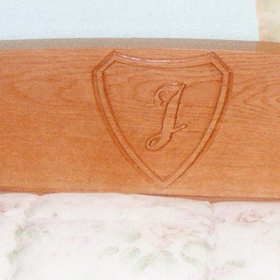 Cabecero de cama con inicial tallada