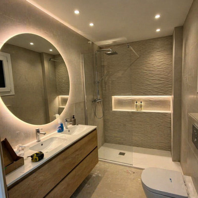 Instalación de iluminación LED en baño con espejo retroiluminado y focos empotrados en Torre del Mar