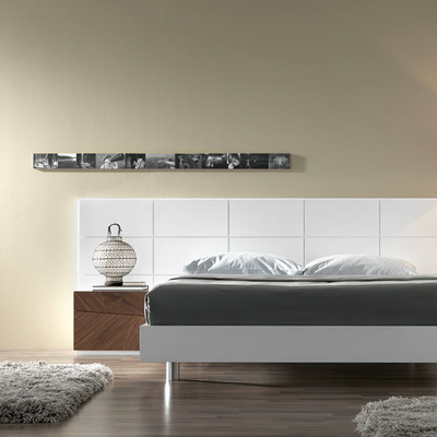 Dormitorio con cabecero panelado en laca blanca.