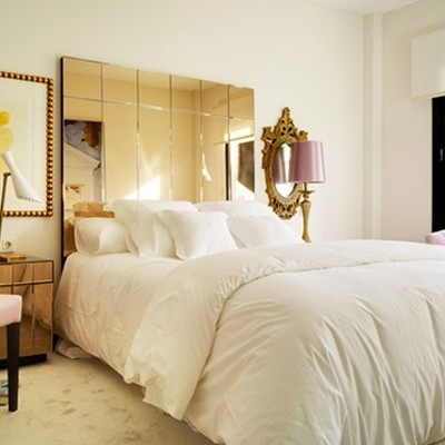 Dormitorio de estilo retro con cabecero de espejo.