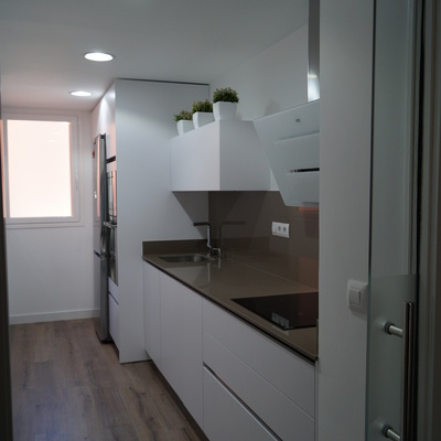 Cocina blanca suelo tarima y puerta de cristal