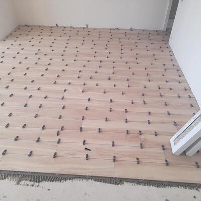 Solado porcelánico efecto madera con sistema de nivelación de alta precisión.