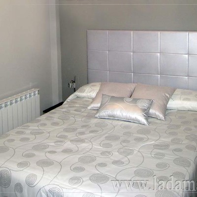 Edredón, cojines y cabecero tapizado en gris plata