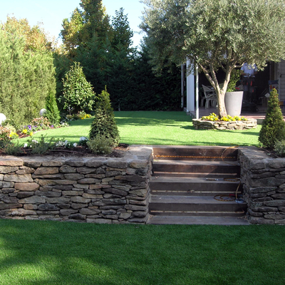 Escalera de traviesas y pradera de césped artificial