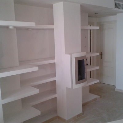 Estanterías con una chimenea en el centro  