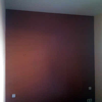 fondo en pared color rojo fuego destacando con el resto en beige en entrada de vivienda