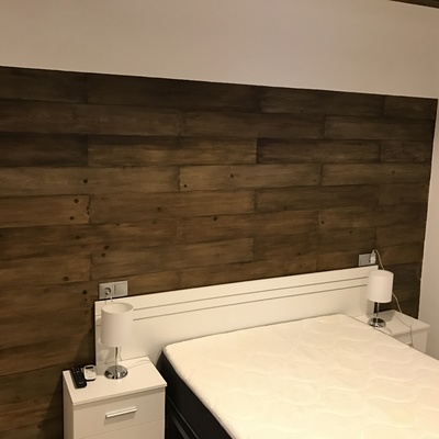 Habitación con cabezal de cama imitación madera