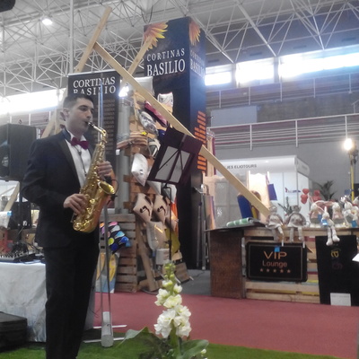 SAXOFONISTA FRENTE AL STAND DE CORTINAS BASILIO