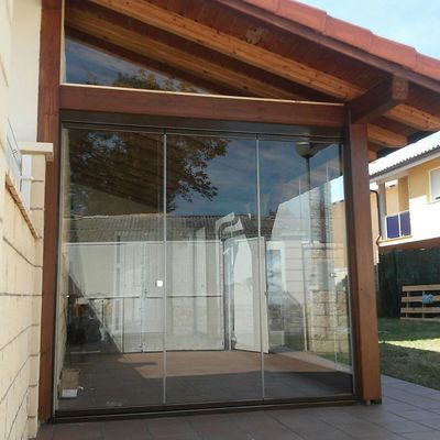 Cerramiento de cortina cristal  de porche de madera