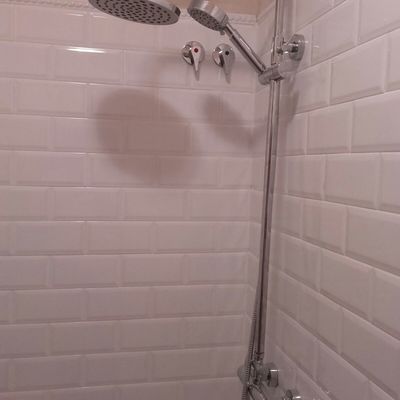 Ducha sobre los azulejos blancos