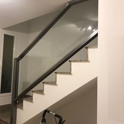 Barandilla de hierro pulido y cristal, barnizado al horno.