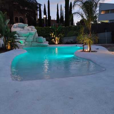 Piscina estilo playa, por la noche