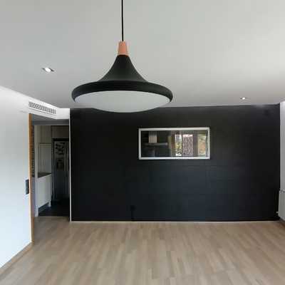 Aplicación de piedra natural en pared de comedor para crear contraste con lámpara de techo