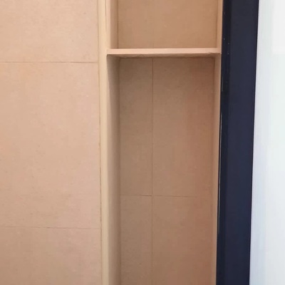 Baldas interiores hechas de obra para colocación de utensilios de ducha.