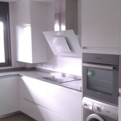 Zona de cocción, con campana en cristal blanco.