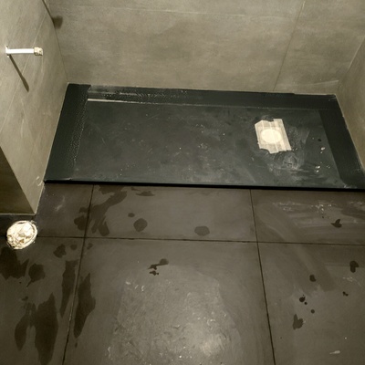 Plato de ducha negro con suelo marrón haciendo juego con la baldosa de la pared perfecto