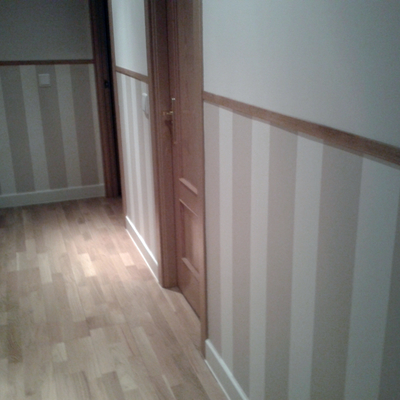 instalación de zócalo de papel pintado en pasillo