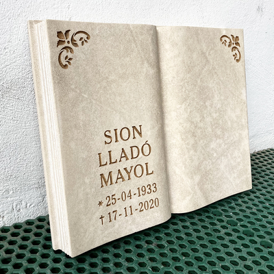 Libro de piedra natural con inscripción y motivos.