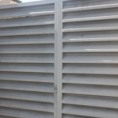 Puerta peatonal con lama veneciana color gris forja.