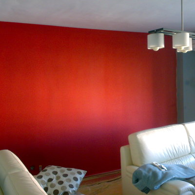 Pared pintada de rojo en salon de vivienda contrastada con gris