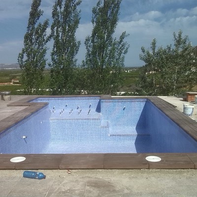 Piscina con jacuzzi y gresite azul niebla
