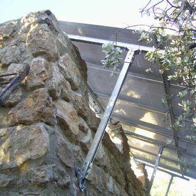 marquesina en vivienda unifamiliar anclada a muro piedra