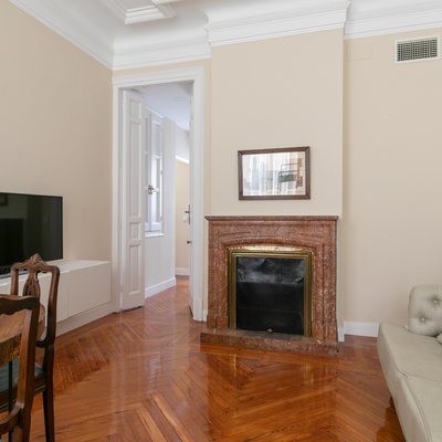 Habitación con parqué de madera natural y chimenea de mármol