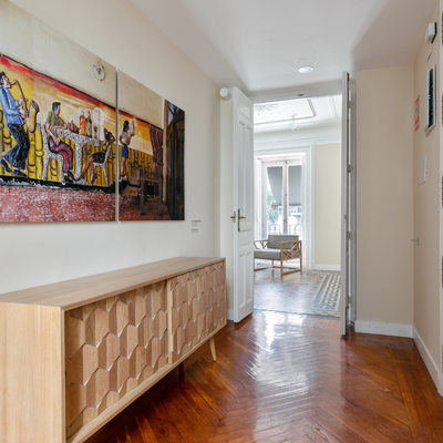 Hall con parqué de madera natural y muebles de diseño