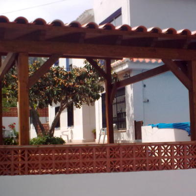 Porche de madera acabado con teja cerámica.