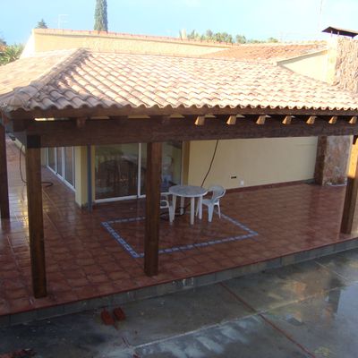 Porche de madera laminada con cubierta a dos aguas.