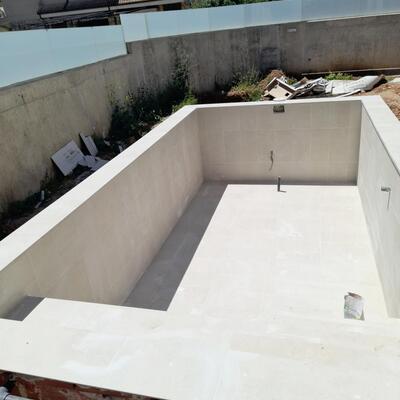 Revestimiento integral y coronación de piscina en gres porcelánico.