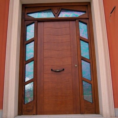 Puerta de entrada principal en pino tea tintado en color nogal claro.  