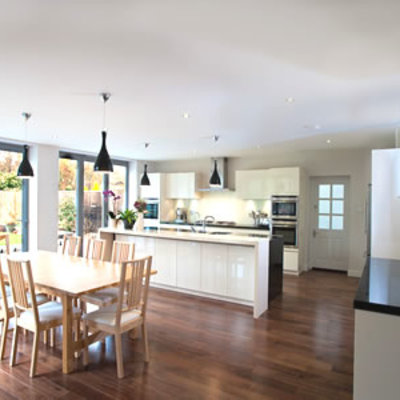 Salón con cocina americana y suelo de madera