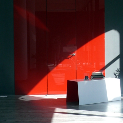 Revestimiento de pared en vidrio rojo brillo y puerta enrasada mismo acabado